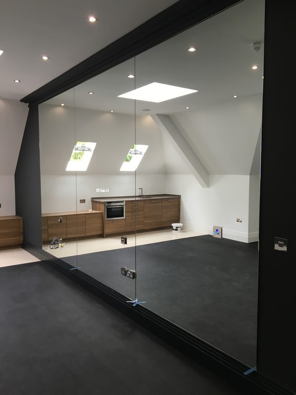 Frameless glass partition in loft conversion by Streatham Hill glaziers